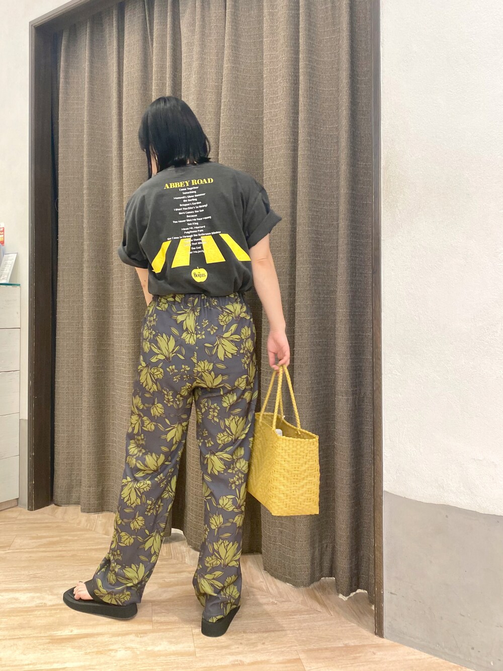 ブラック系のTシャツ/カットソー、グレー系のその他パンツ、イエロー系のトートバッグを着用したレディースの春コーディネートの5枚目の写真