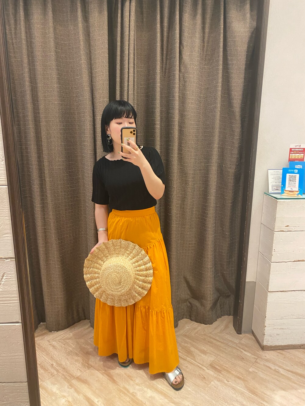 ブラック系のニット/セーター、オレンジ系のスカート、シルバー系のその他シューズを着用したレディースの春コーディネートの2枚目の写真