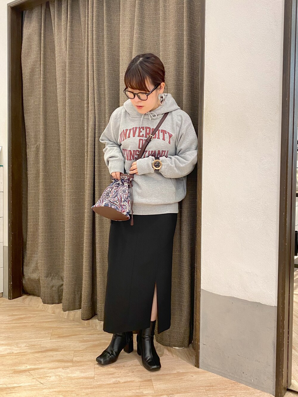 ブルー系のショルダーバッグ、ブラック系のスカート、グレー系のパーカーを着用したレディースの冬コーディネートの3枚目の写真