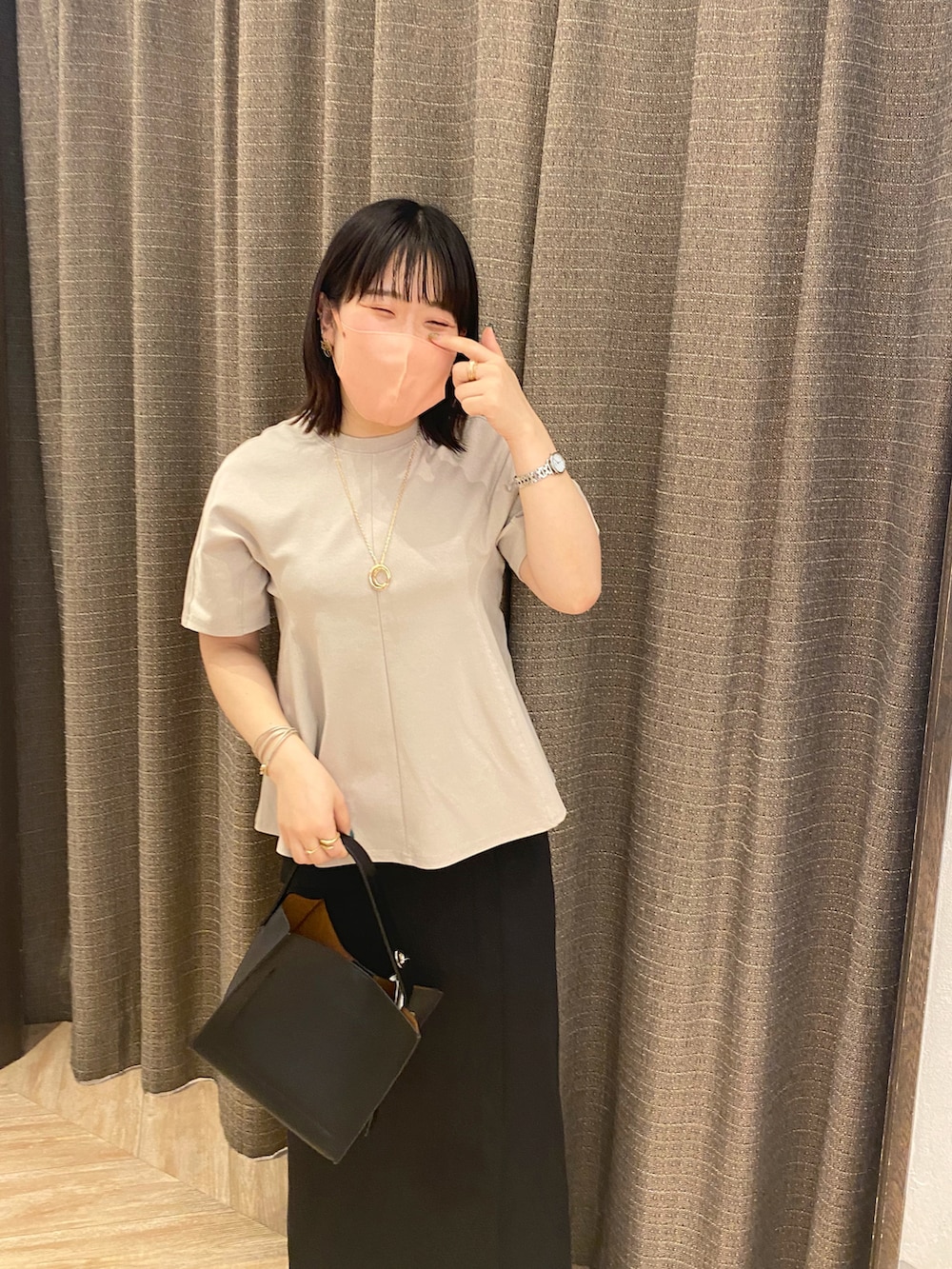 ブラック系のトートバッグ、ベージュ系のTシャツ/カットソー、ブラック系のスカートを着用したレディースの夏コーディネートの4枚目の写真