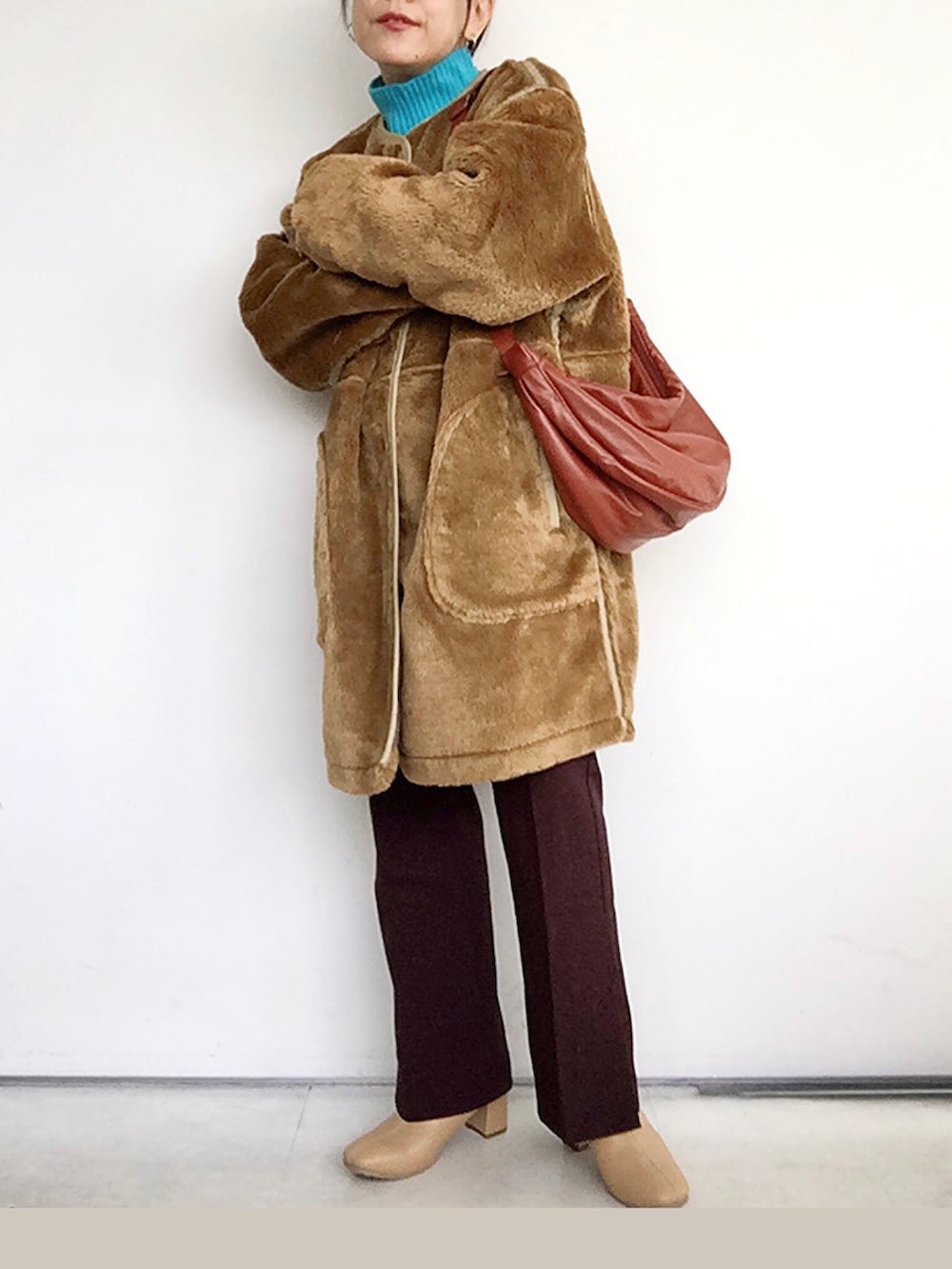 ブラウン系のブルゾン、ブルー系のニット/セーター、レッド系のその他パンツを着用したレディースの冬コーディネートの2枚目の写真