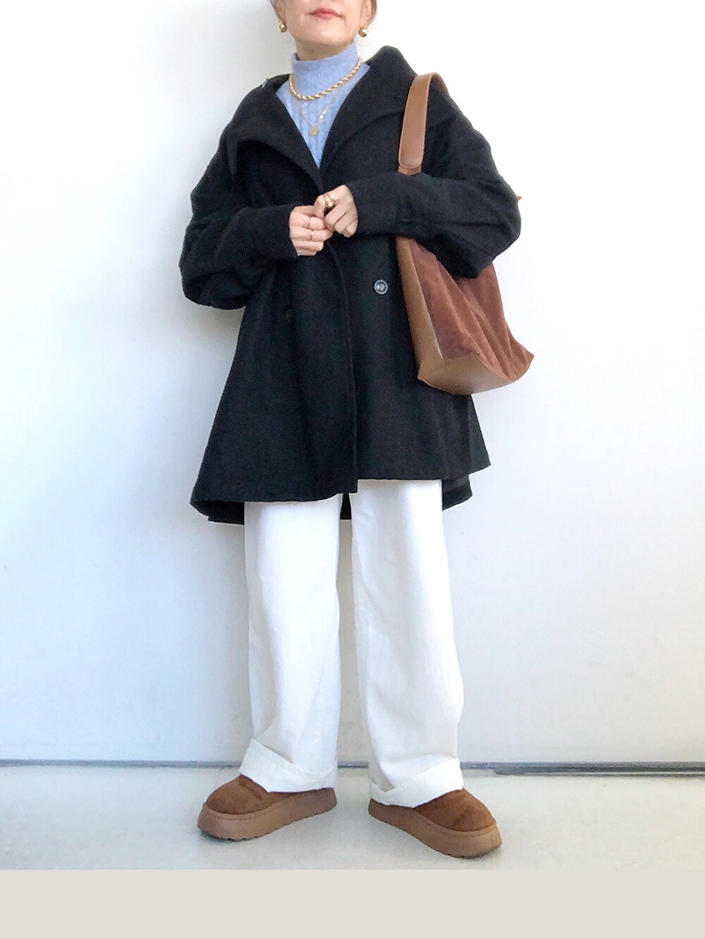 ブラック系のその他アウター、ブルー系のニット/セーター、ホワイト系のデニムパンツを着用したレディースの冬コーディネートの2枚目の写真