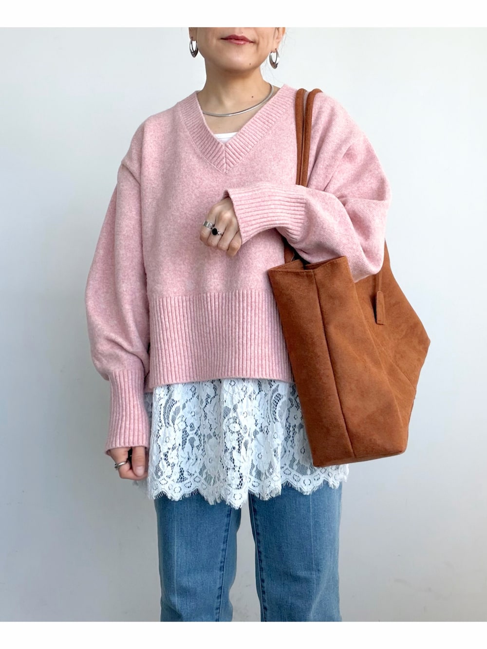 ピンク系のニット/セーター、ホワイト系のタンクトップ、ブラウン系のショルダーバッグを着用したレディースの冬コーディネートの4枚目の写真