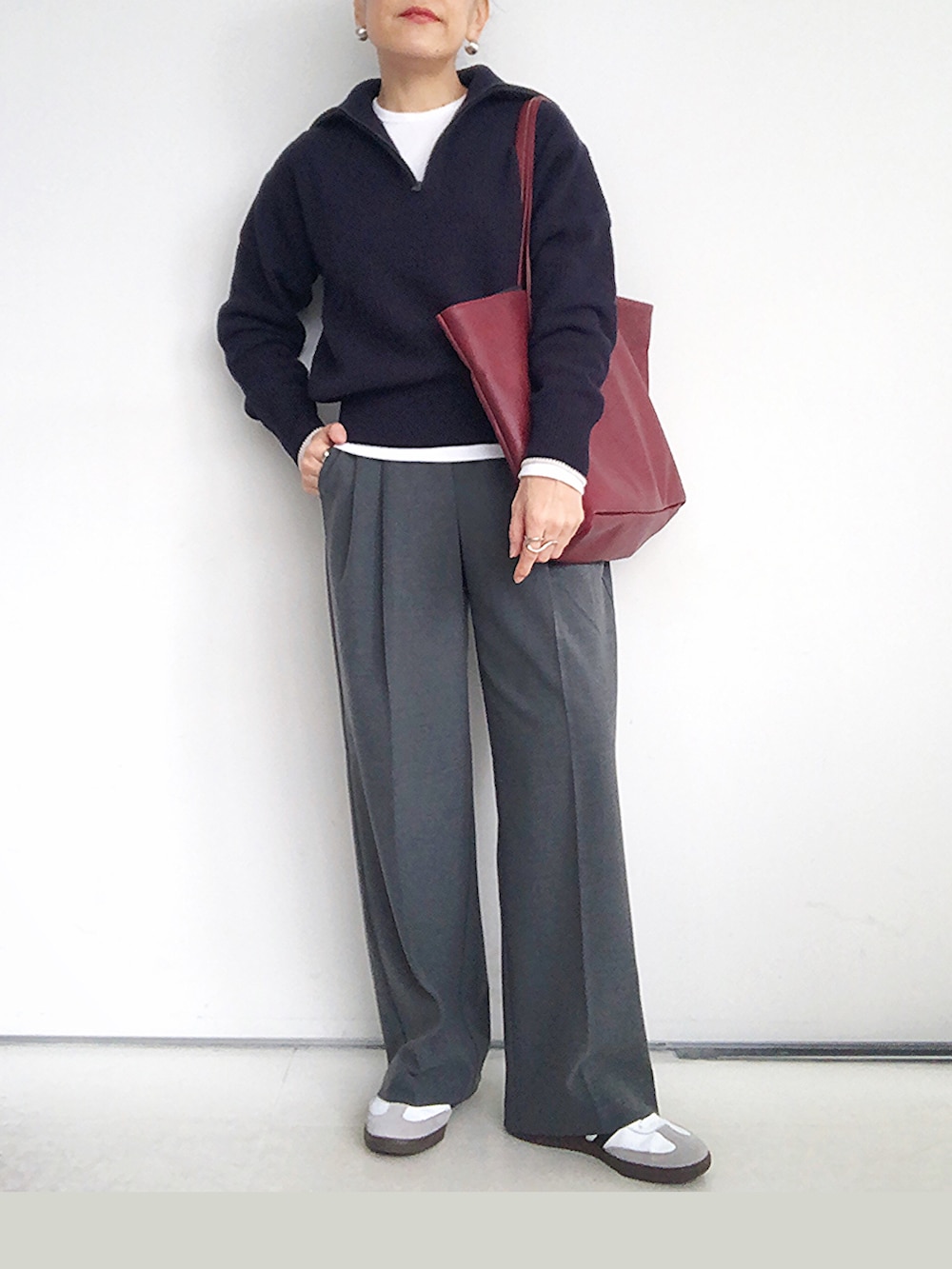 ブルー系のニット/セーター、グレー系のスラックス、レッド系のバックパック/リュックを着用したレディースの秋コーディネートの3枚目の写真