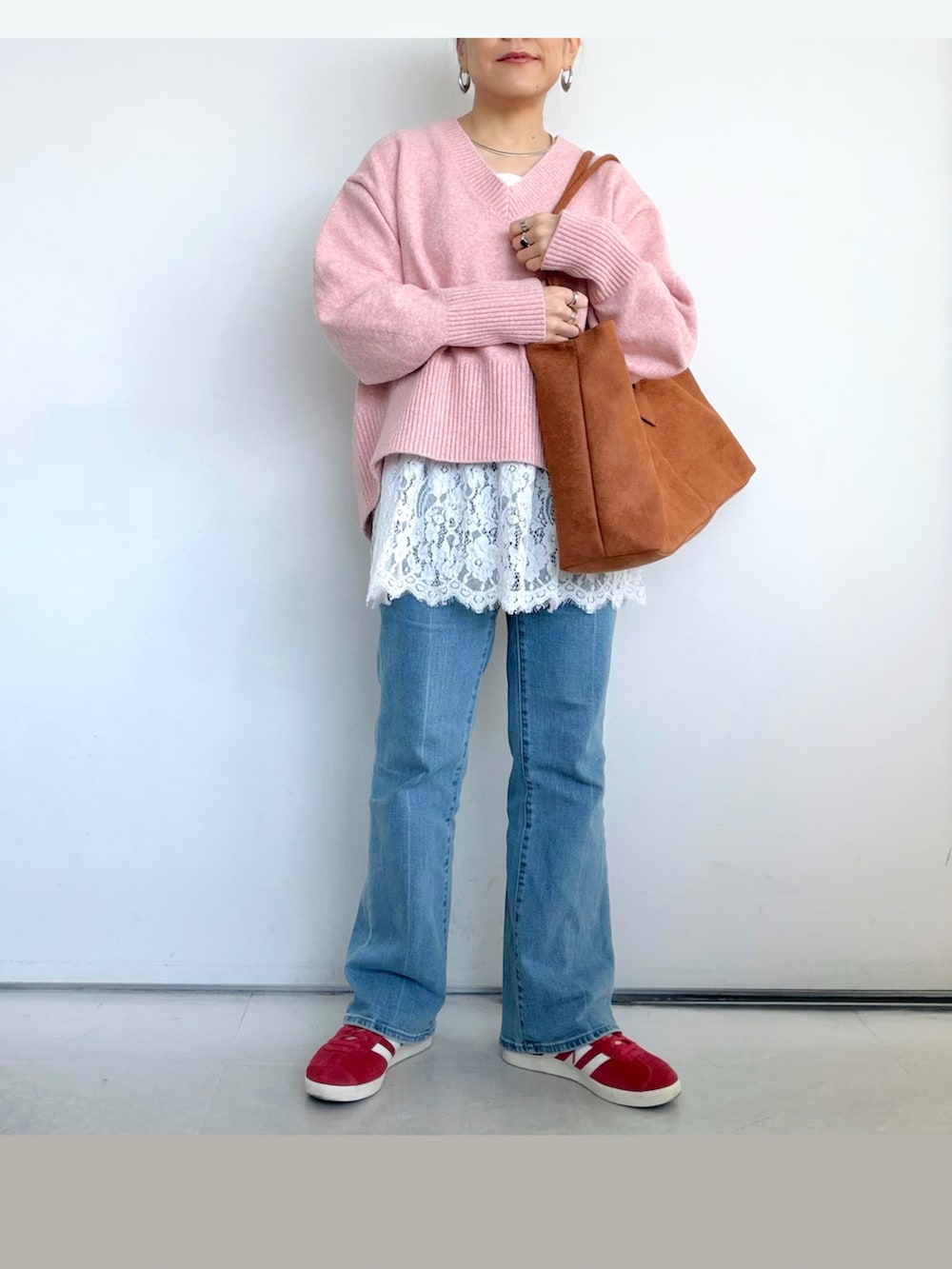 ピンク系のニット/セーター、ホワイト系のタンクトップ、ブラウン系のショルダーバッグを着用したレディースの冬コーディネートの2枚目の写真