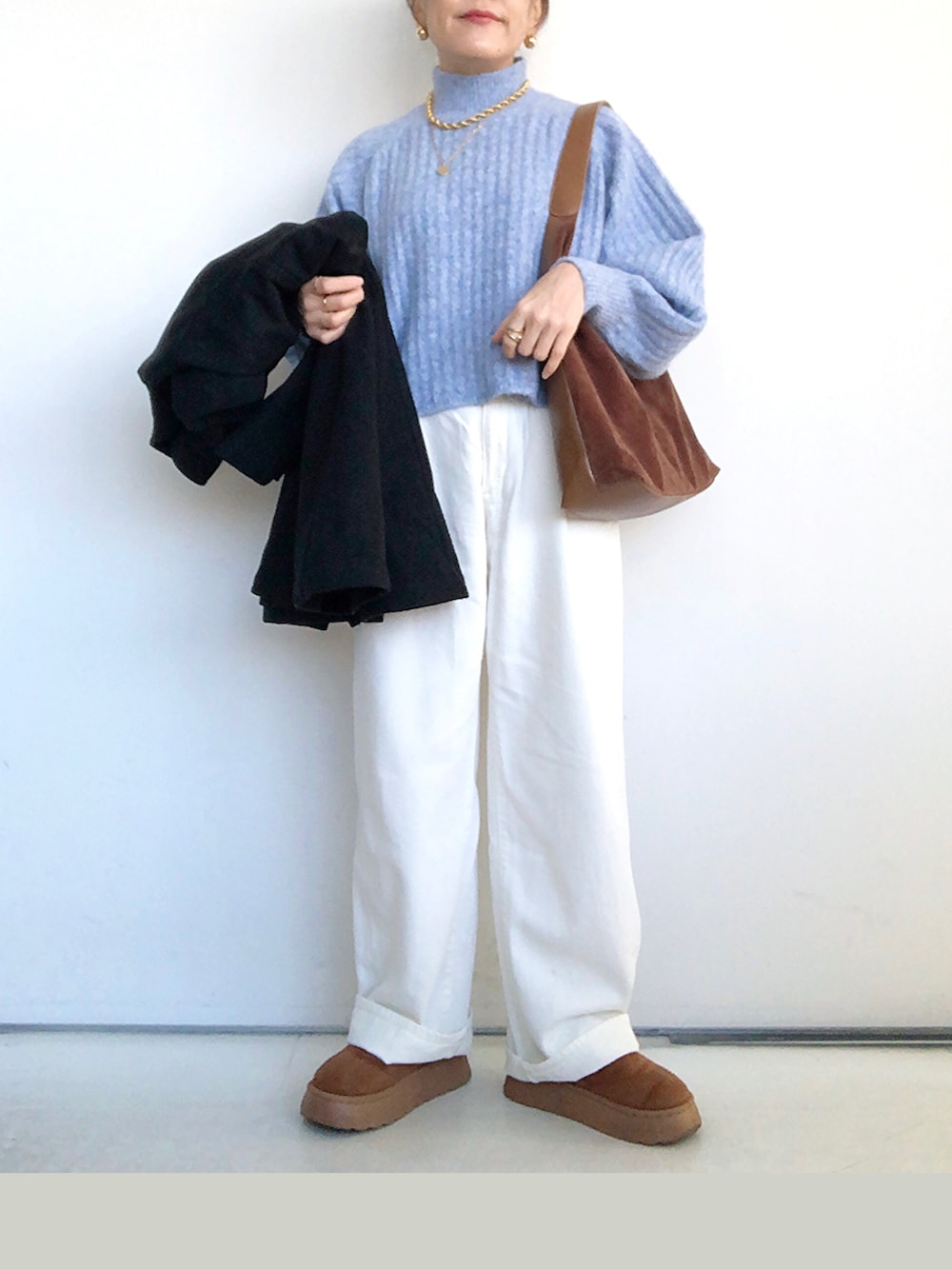 ブラック系のその他アウター、ブルー系のニット/セーター、ホワイト系のデニムパンツを着用したレディースの冬コーディネートの4枚目の写真