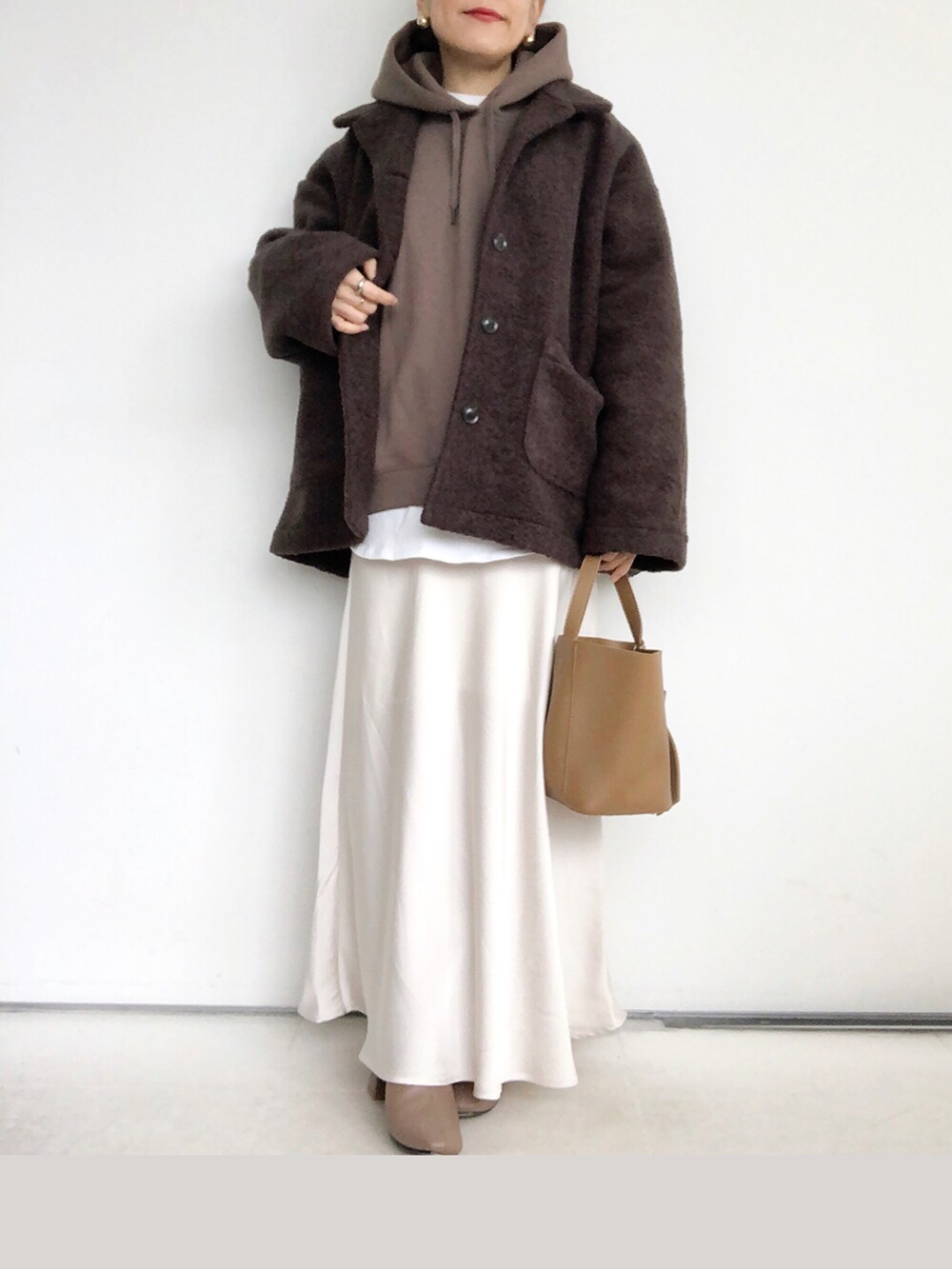 ブラウン系のパーカー、ホワイト系のスカート、ブラウン系のショルダーバッグを着用したレディースの秋コーディネートの5枚目の写真