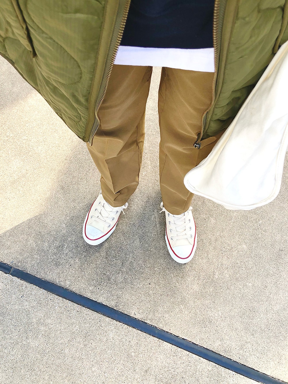 ブルー系のスウェット、ブラウン系のその他パンツ、ホワイト系のスニーカーを着用したレディースの冬コーディネートの4枚目の写真