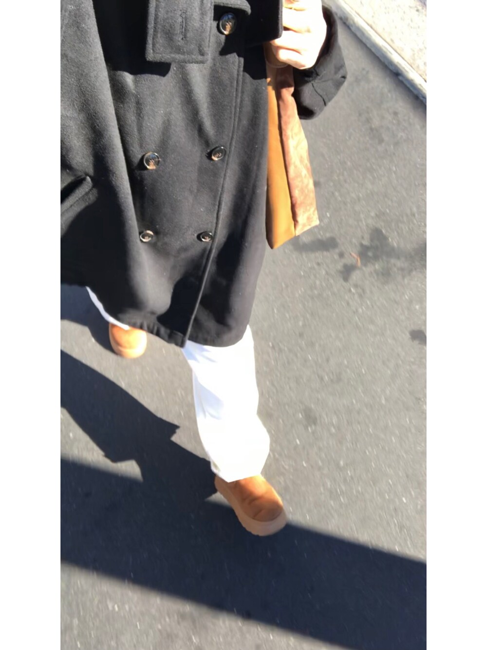 ブラック系のその他アウター、ブルー系のニット/セーター、ホワイト系のデニムパンツを着用したレディースの冬コーディネートの5枚目の写真