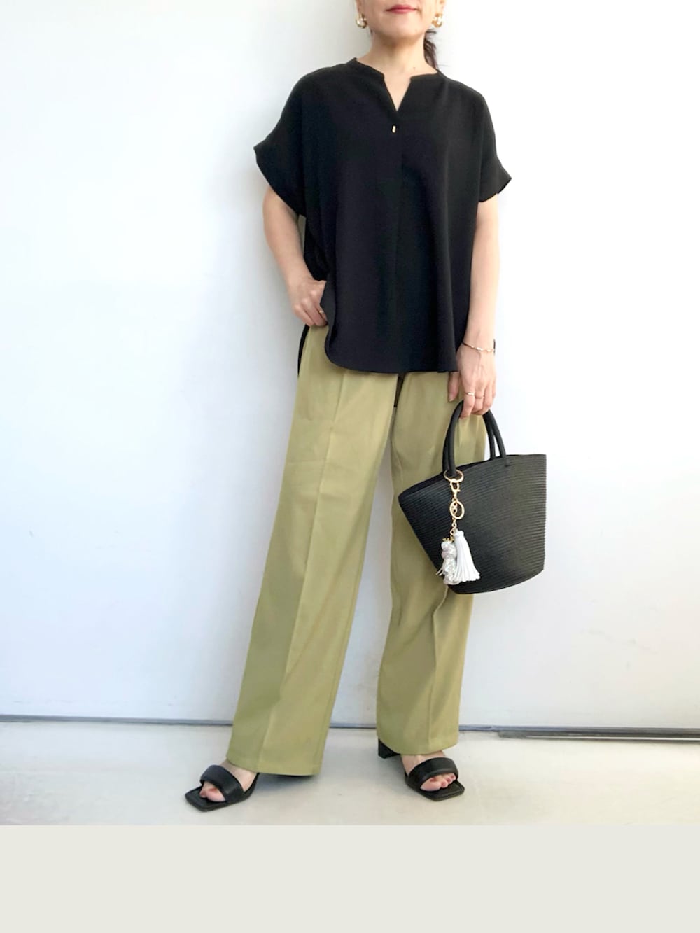 グリーン系のスラックス、ブラック系のシャツ/ブラウス、ブラック系のトートバッグを着用したレディースの夏コーディネートの3枚目の写真