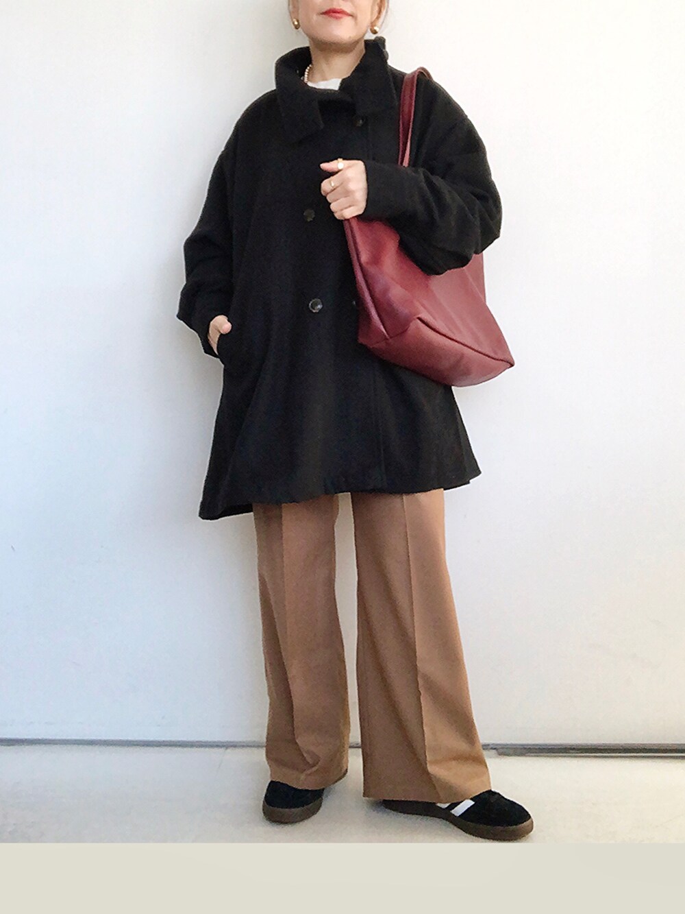 ブラック系のその他アウター、ホワイト系のニット/セーター、ブラウン系のその他パンツを着用したレディースの冬コーディネートの2枚目の写真