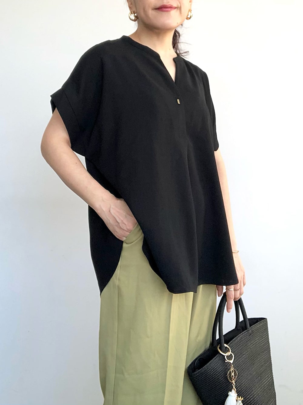 グリーン系のスラックス、ブラック系のシャツ/ブラウス、ブラック系のトートバッグを着用したレディースの夏コーディネートの4枚目の写真