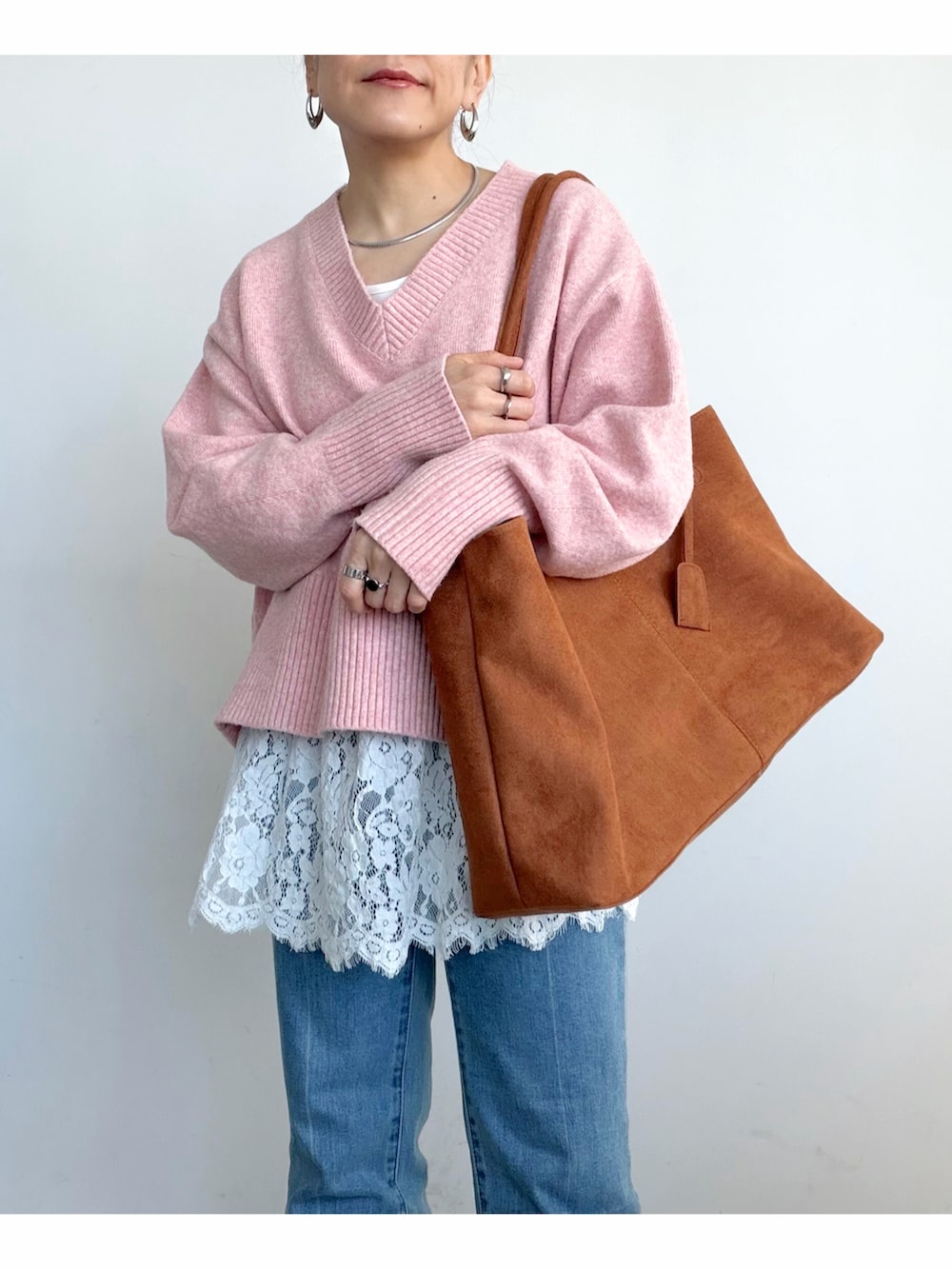 ピンク系のニット/セーター、ホワイト系のタンクトップ、ブラウン系のショルダーバッグを着用したレディースの冬コーディネートの3枚目の写真