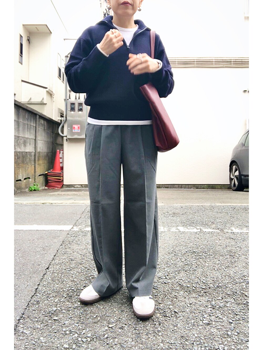 ブルー系のニット/セーター、グレー系のスラックス、レッド系のバックパック/リュックを着用したレディースの秋コーディネートの4枚目の写真