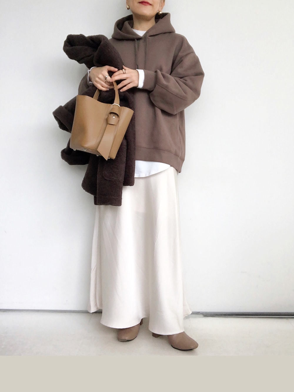 ブラウン系のパーカー、ホワイト系のスカート、ブラウン系のショルダーバッグを着用したレディースの秋コーディネートの4枚目の写真