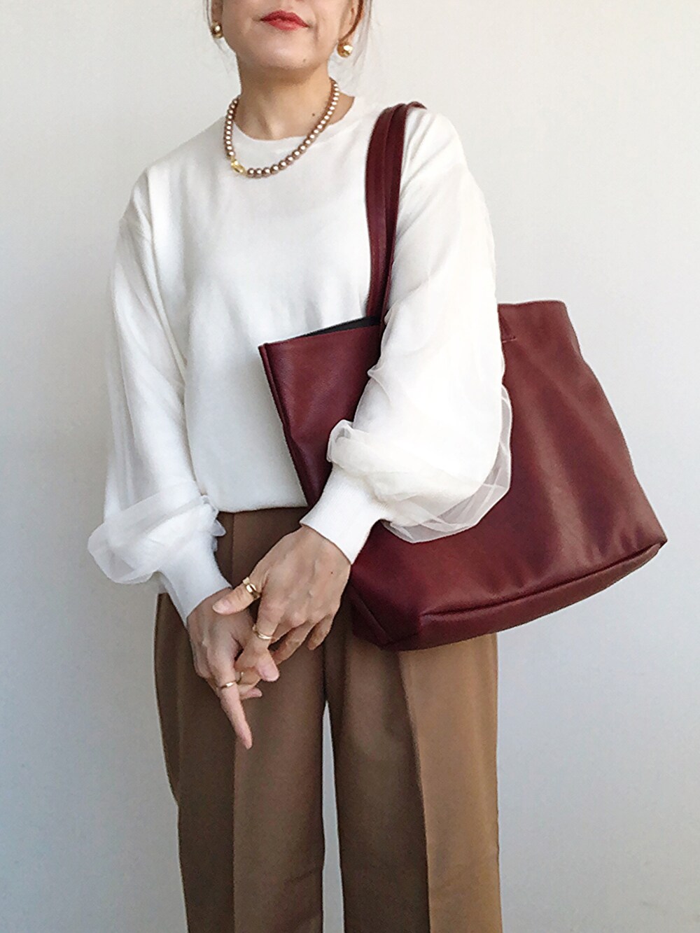 ブラック系のその他アウター、ホワイト系のニット/セーター、ブラウン系のその他パンツを着用したレディースの冬コーディネートの5枚目の写真