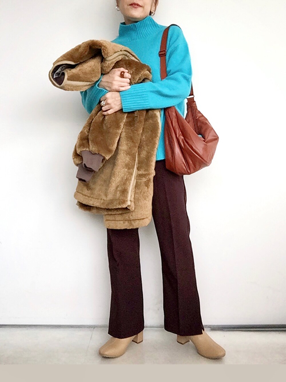 ブラウン系のブルゾン、ブルー系のニット/セーター、レッド系のその他パンツを着用したレディースの冬コーディネートの4枚目の写真