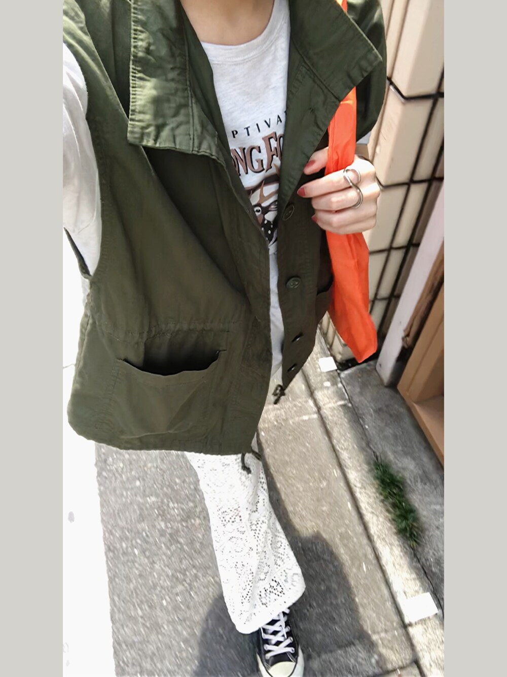 ホワイト系のスラックス、グリーン系のベスト、ベージュ系のTシャツ/カットソーを着用したレディースの夏コーディネートの2枚目の写真