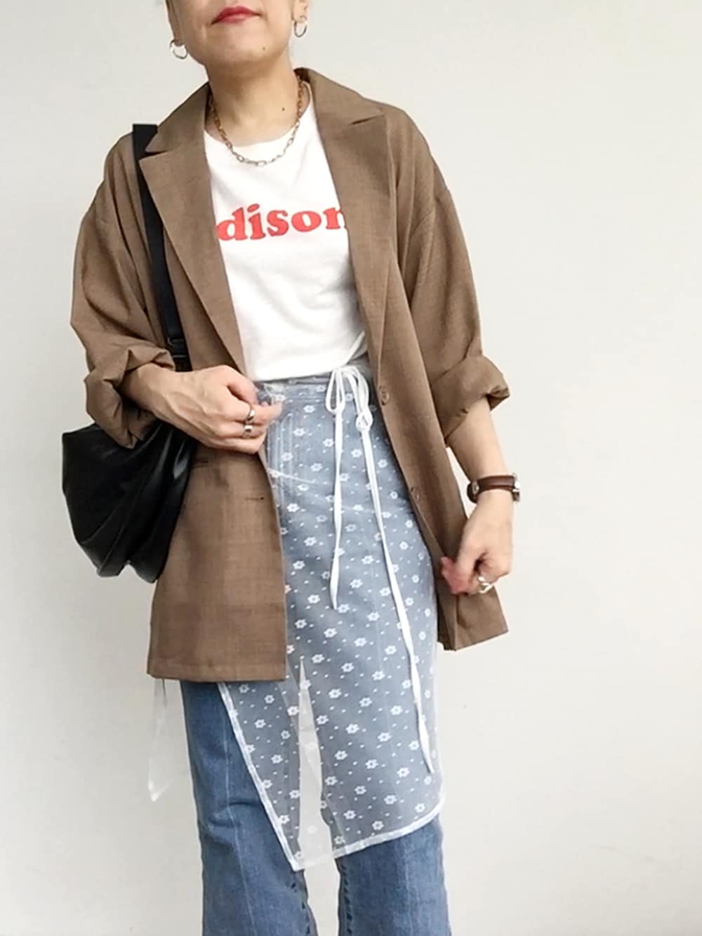 ホワイト系のスカート、ベージュ系のテーラードジャケット、レッド系のスニーカーを着用したレディースの夏コーディネートの4枚目の写真