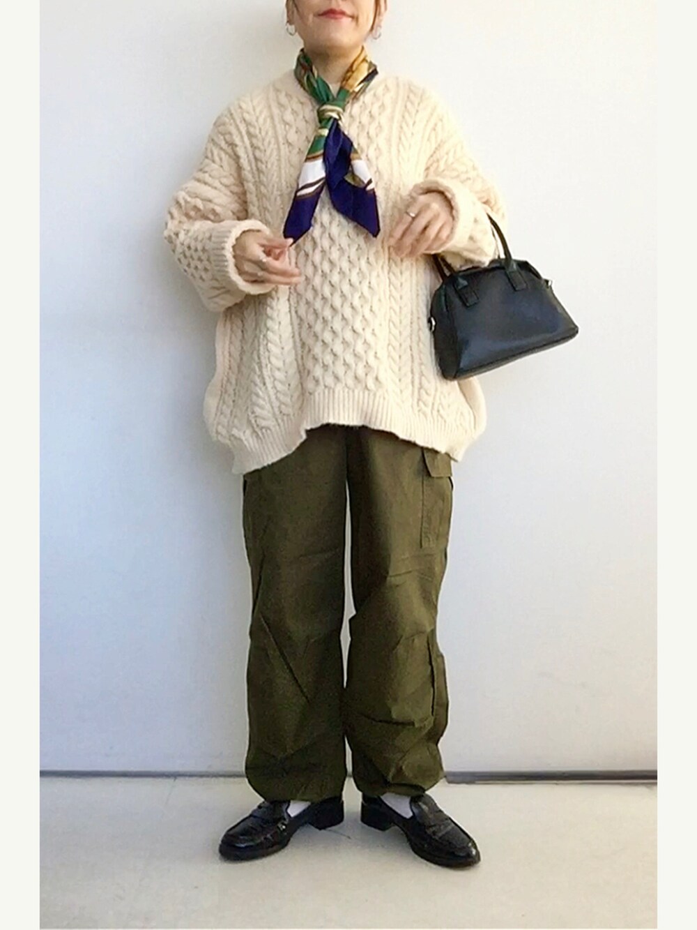 ホワイト系のニット/セーター、グリーン系のカーゴパンツ、ブラック系のローファーを着用したレディースの冬コーディネートの2枚目の写真