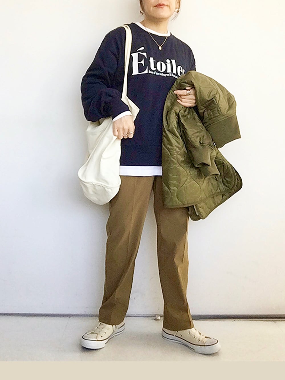 ブルー系のスウェット、ブラウン系のその他パンツ、ホワイト系のスニーカーを着用したレディースの冬コーディネートの3枚目の写真