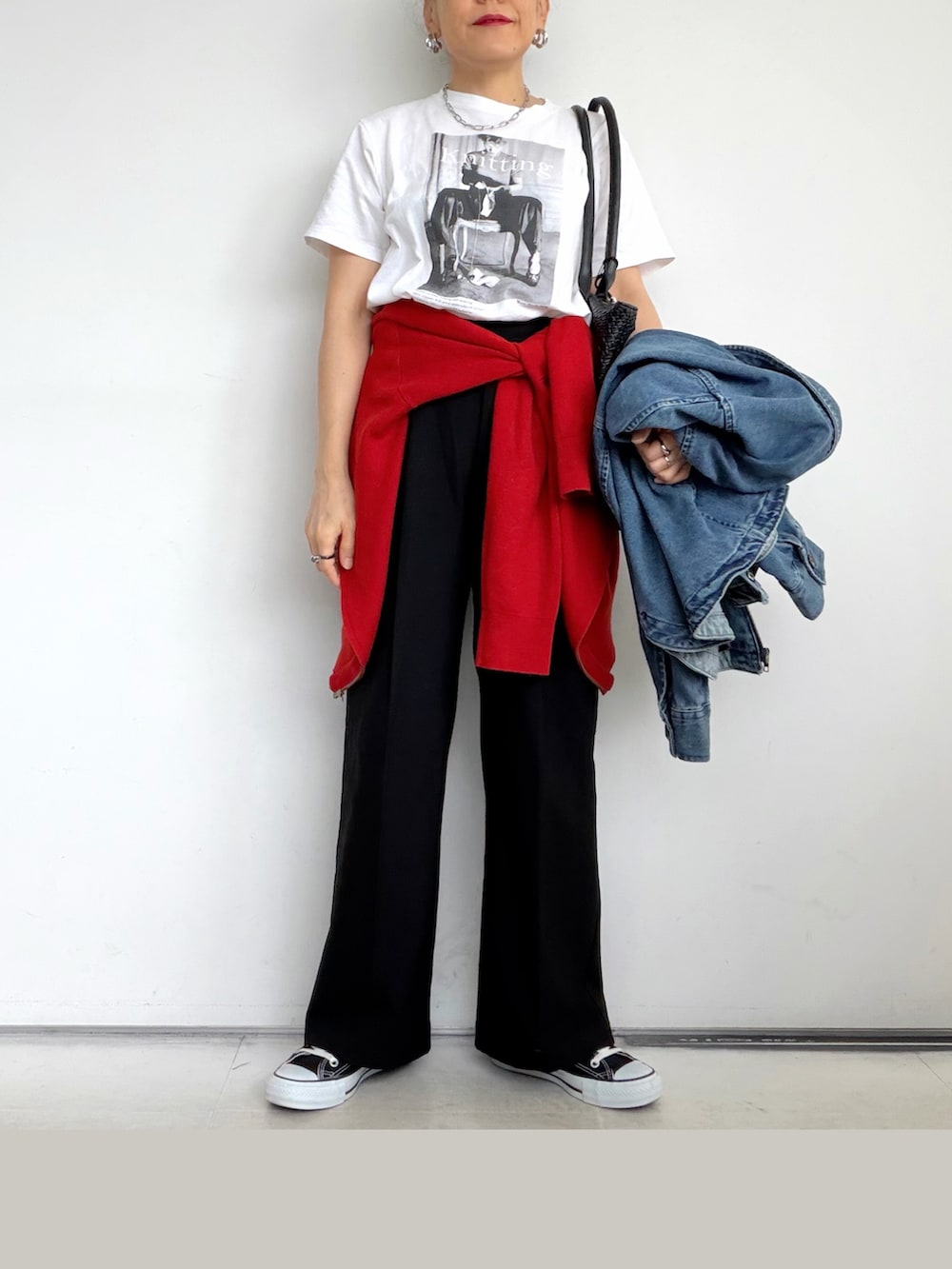 ブラック系のスニーカー、ホワイト系のTシャツ/カットソー、レッド系のカーディガン/ボレロを着用したレディースの秋コーディネートの3枚目の写真