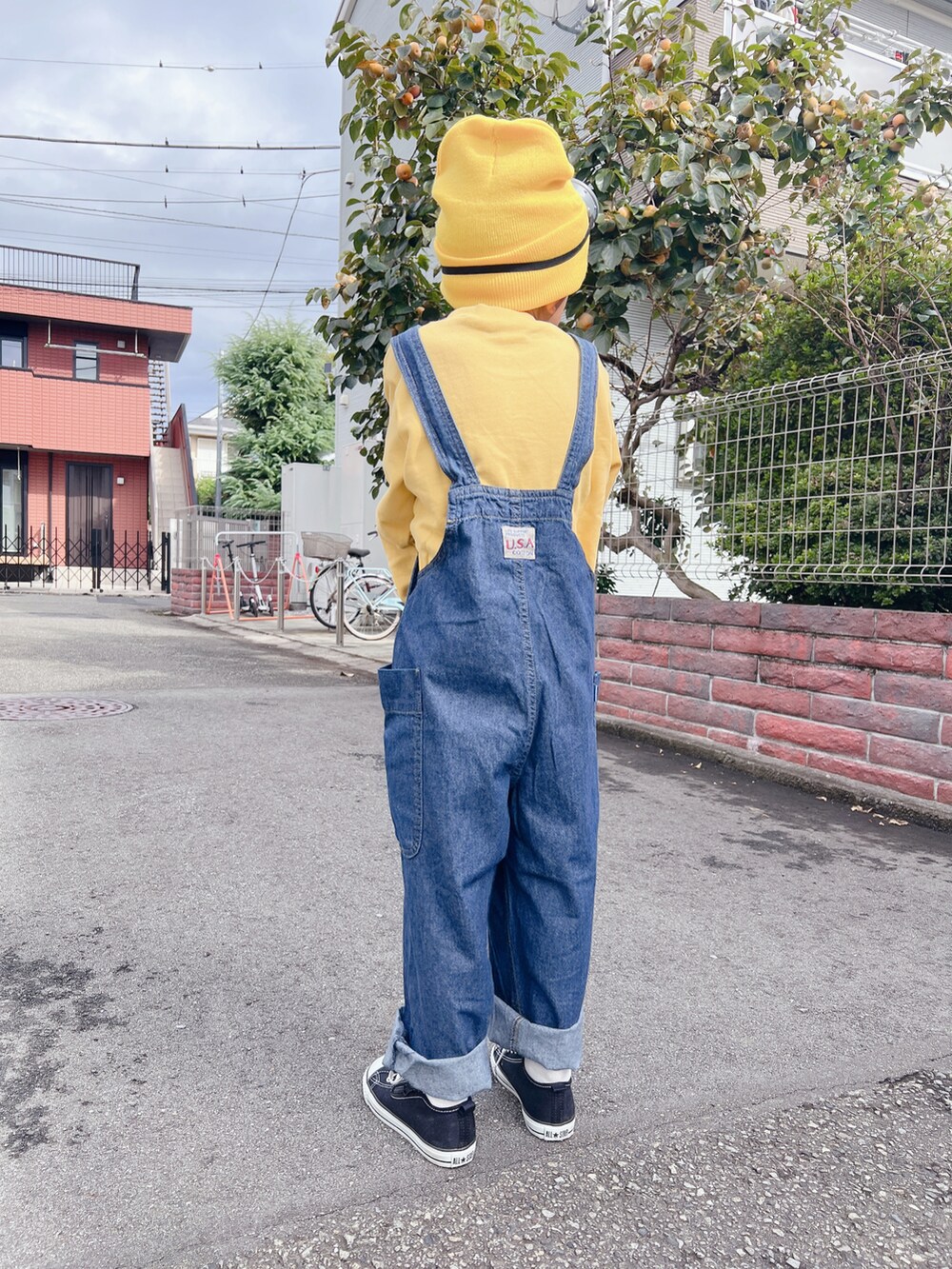 ブラック系のスニーカー、ブルー系のサロペット/オーバーオールを着用したレディースの秋コーディネートの2枚目の写真