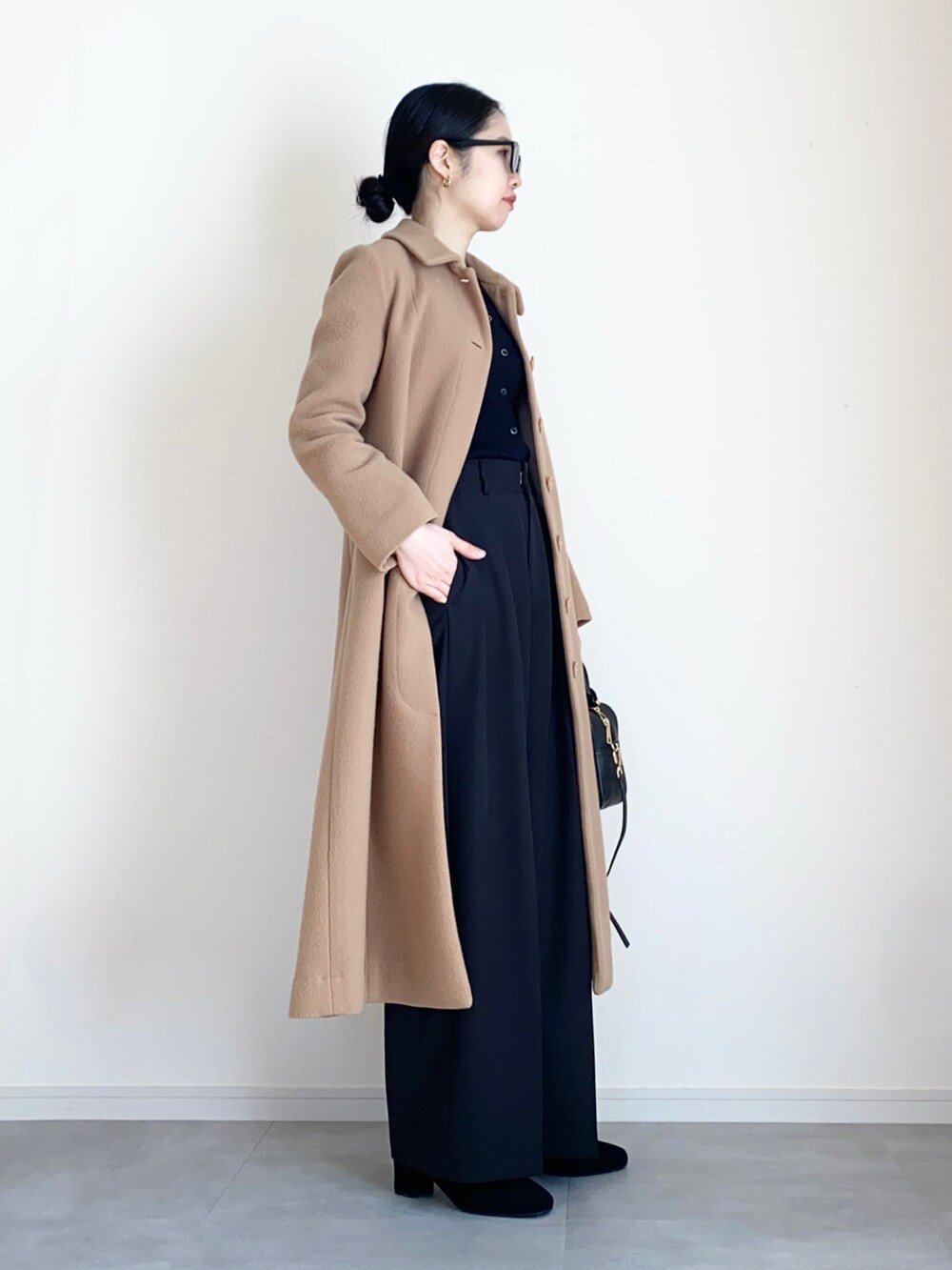 ベージュ系のその他アウター、ブラック系のカーディガン/ボレロ、ブラック系のその他パンツを着用したレディースの冬コーディネートの3枚目の写真