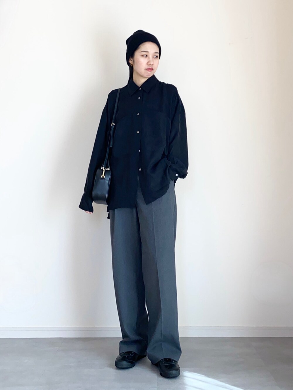 ブラック系のシャツ/ブラウス、グレー系のスラックス、ブラック系のスリッポンを着用したレディースの春コーディネートの3枚目の写真