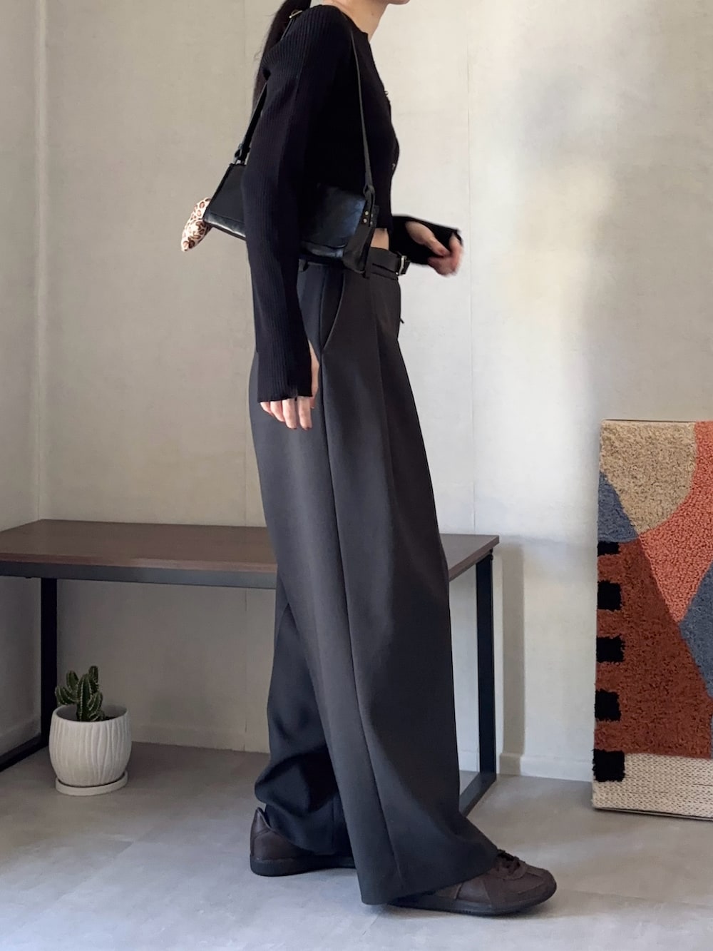 ブラック系のカーディガン/ボレロ、グレー系のその他パンツ、ブラウン系のスニーカーを着用したレディースの秋コーディネートの2枚目の写真