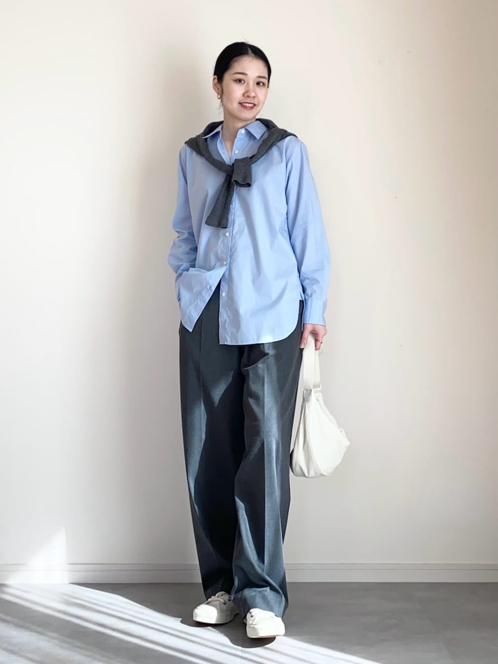 ブルー系のシャツ/ブラウス、グレー系のカーディガン/ボレロ、グレー系のスラックスを着用したレディースの冬コーディネートの3枚目の写真