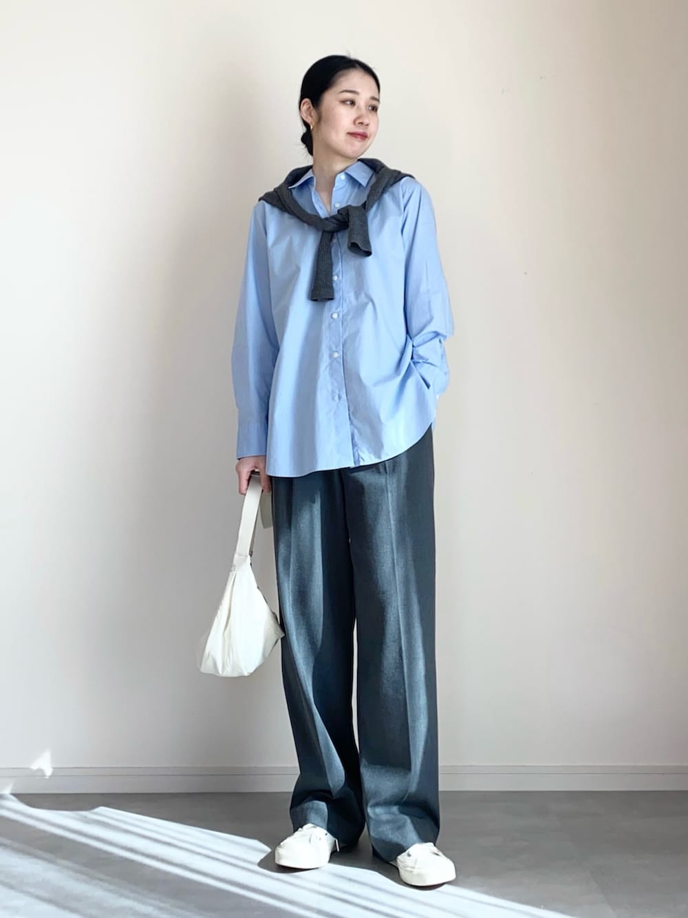 ブルー系のシャツ/ブラウス、グレー系のカーディガン/ボレロ、グレー系のスラックスを着用したレディースの冬コーディネートの2枚目の写真
