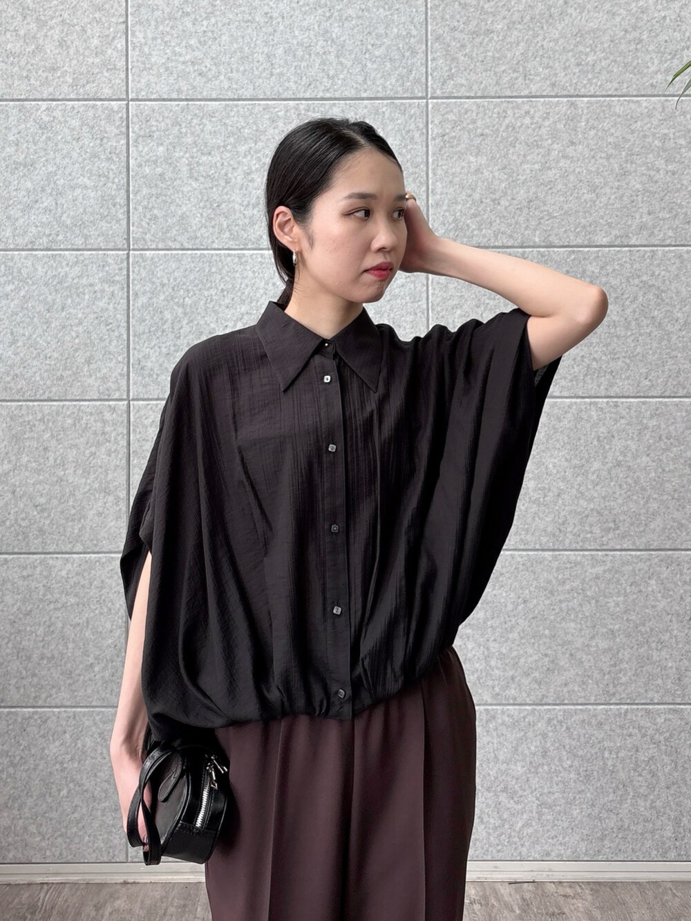 ブラック系のシャツ/ブラウス、ブラウン系のその他パンツ、ブラック系のハンドバッグを着用したレディースの秋コーディネートの4枚目の写真