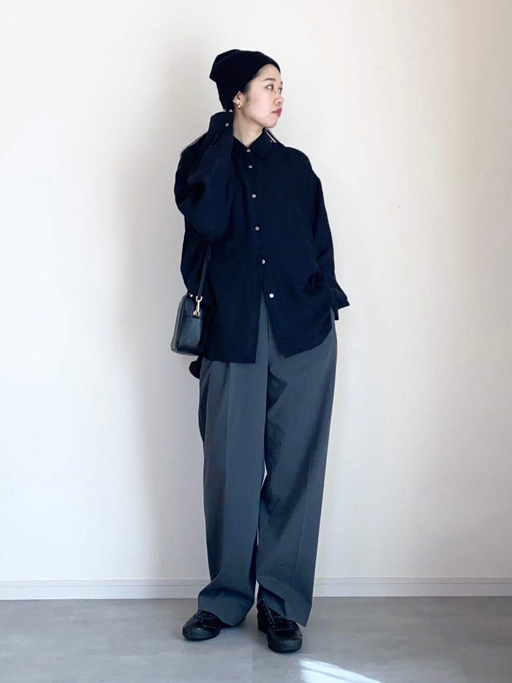 ブラック系のシャツ/ブラウス、グレー系のスラックス、ブラック系のスリッポンを着用したレディースの春コーディネートの2枚目の写真