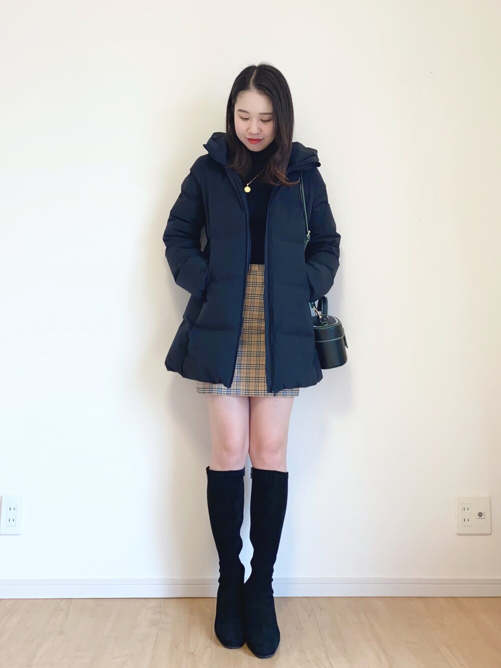 ブラック系のダウンジャケット/コート、ブラック系のショルダーバッグを着用したレディースの冬コーディネートの2枚目の写真