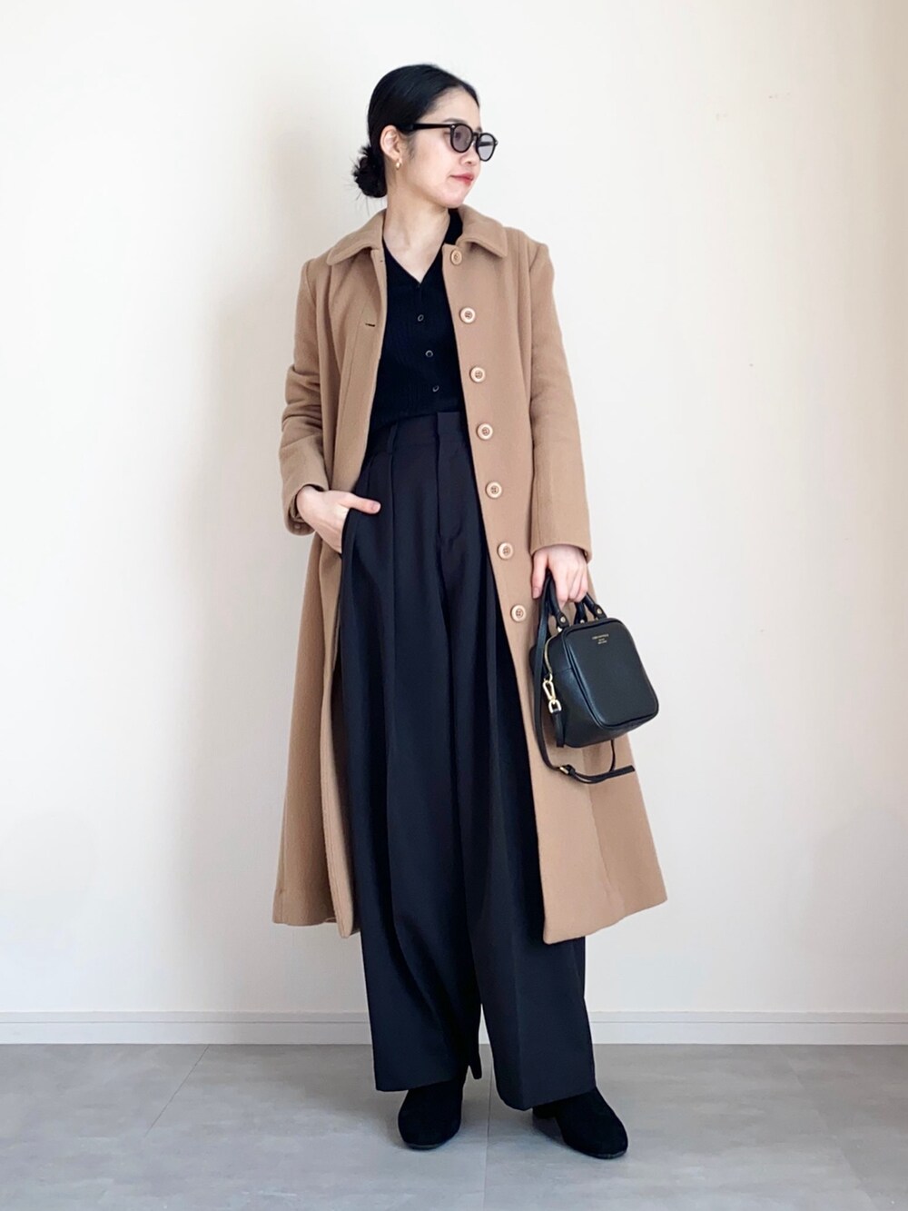 ベージュ系のその他アウター、ブラック系のカーディガン/ボレロ、ブラック系のその他パンツを着用したレディースの冬コーディネートの4枚目の写真