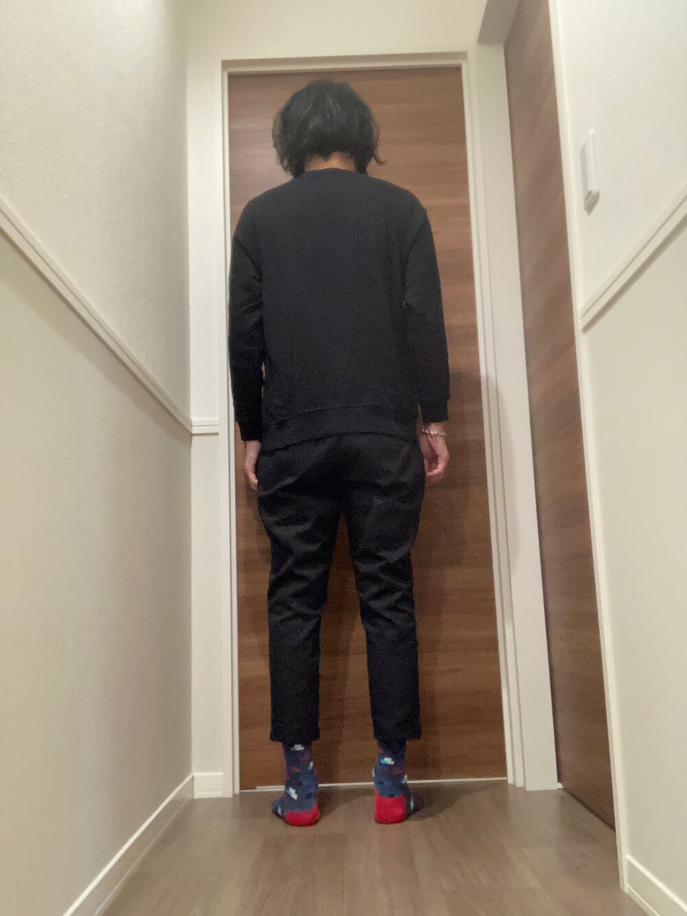 ブラック系のスウェット、ブラック系のチノパンツを着用したメンズの秋コーディネートの3枚目の写真