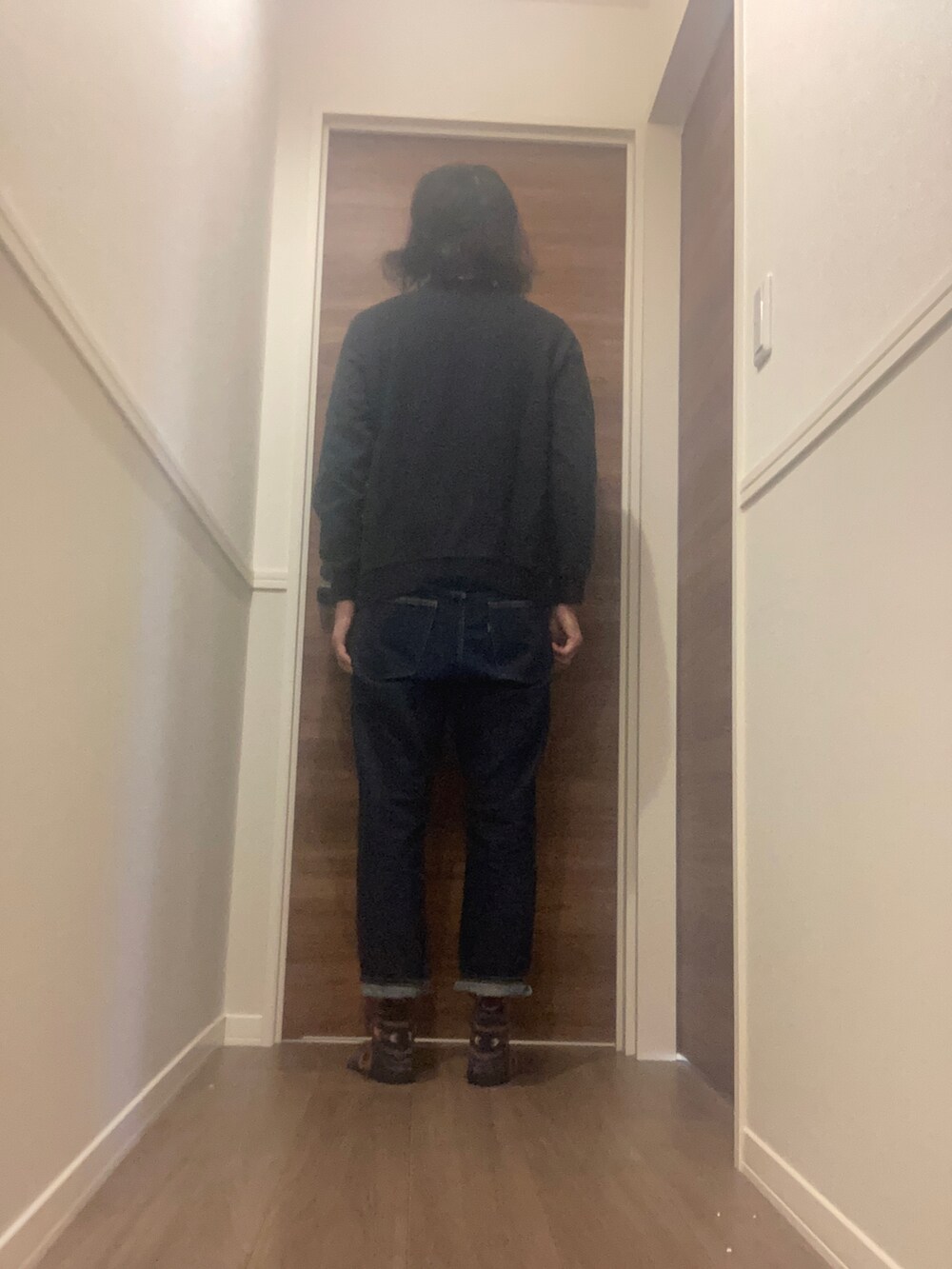 ブラック系のスウェット、ブルー系のデニムパンツを着用したメンズの冬コーディネートの3枚目の写真