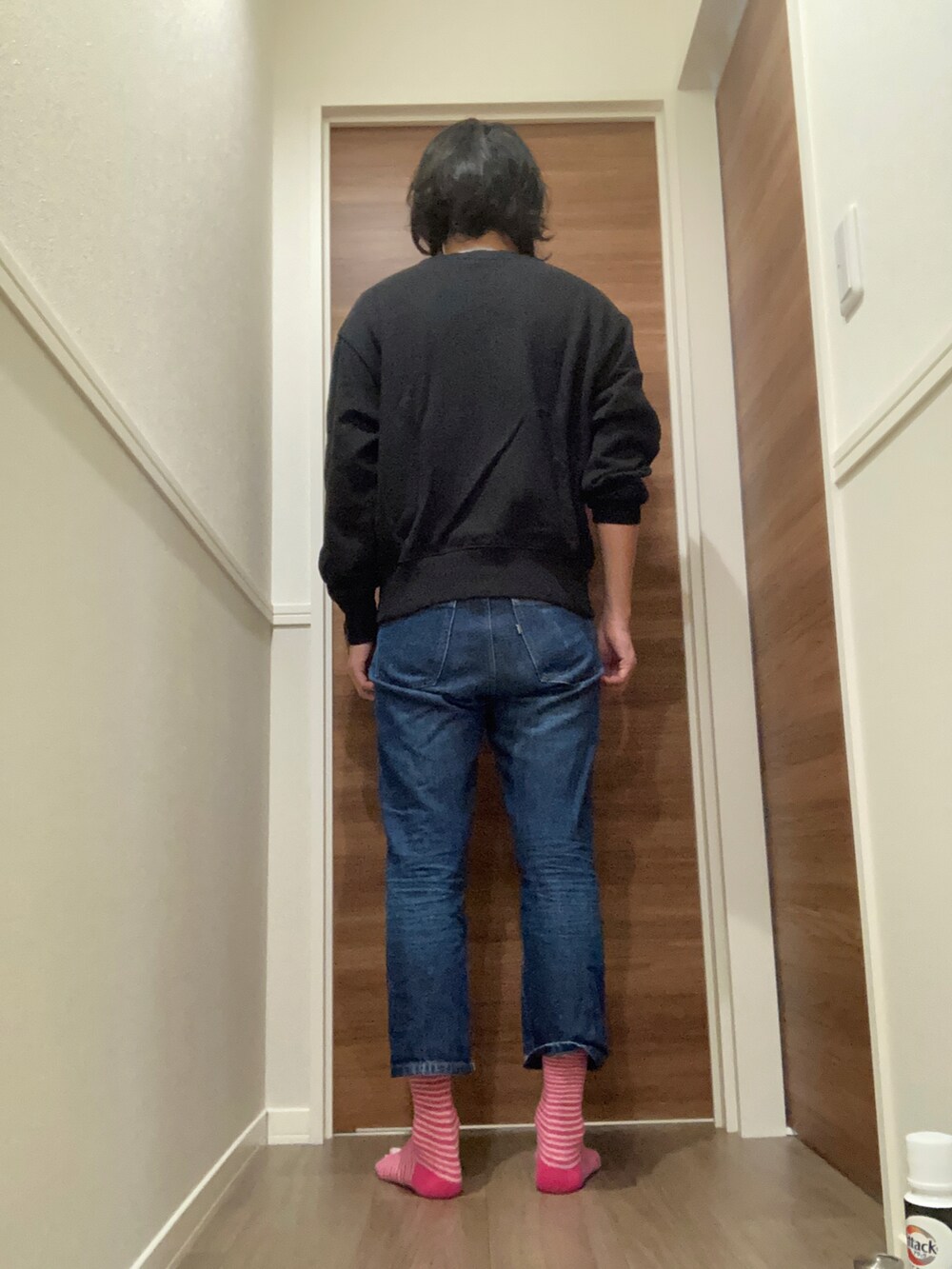 ブラック系のスウェット、ブルー系のデニムパンツを着用したメンズの秋コーディネートの3枚目の写真