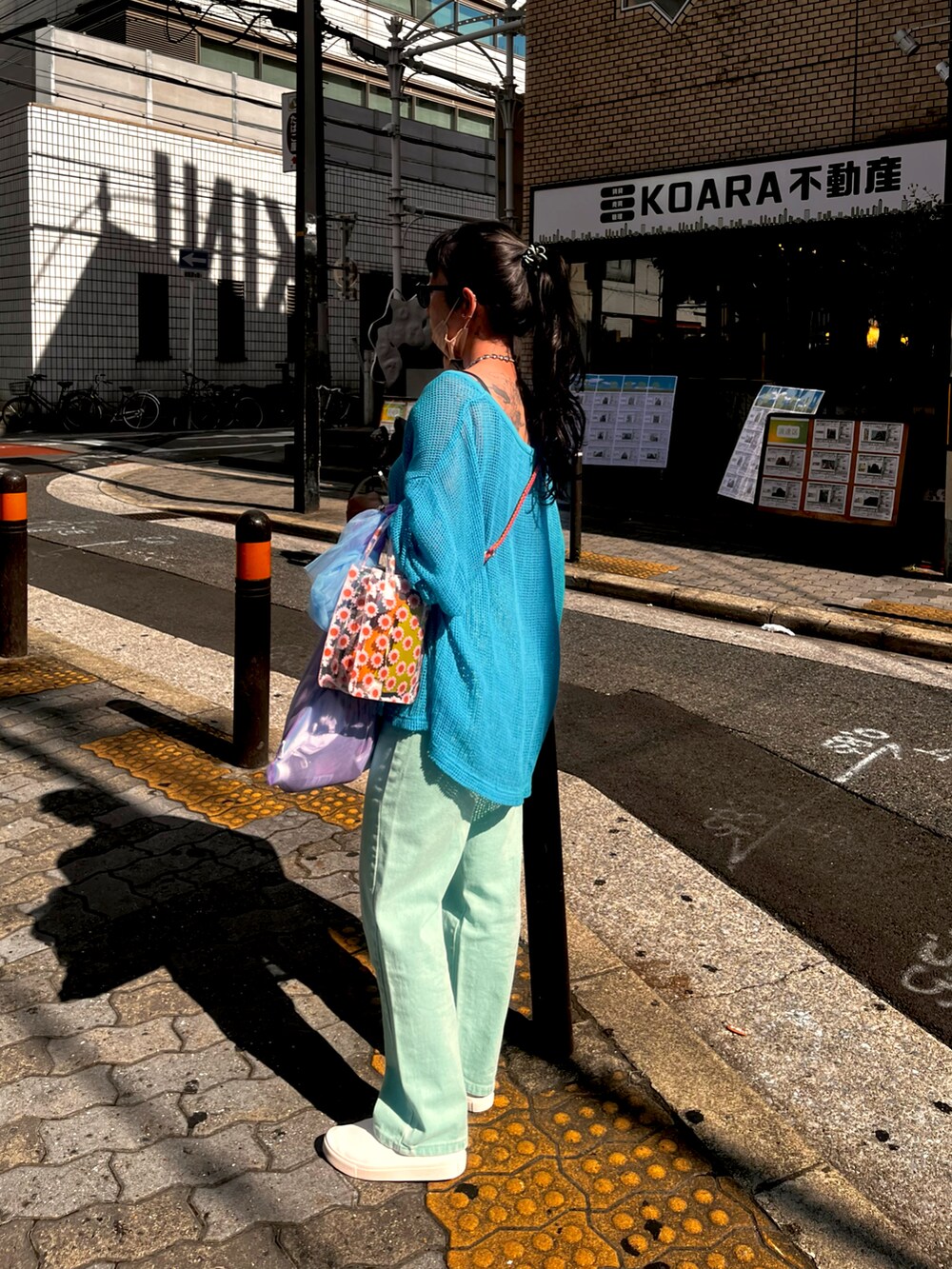 グリーン系のデニムパンツ、ホワイト系のスリッポン、ピンク系のバッグを着用したレディースの夏コーディネートの2枚目の写真