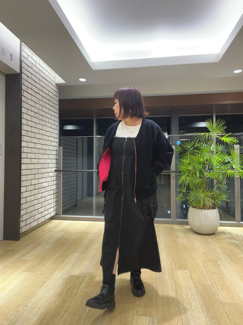 ブラック系のブルゾン、ブラック系のジャンパースカートを着用したレディースの秋コーディネートの3枚目の写真