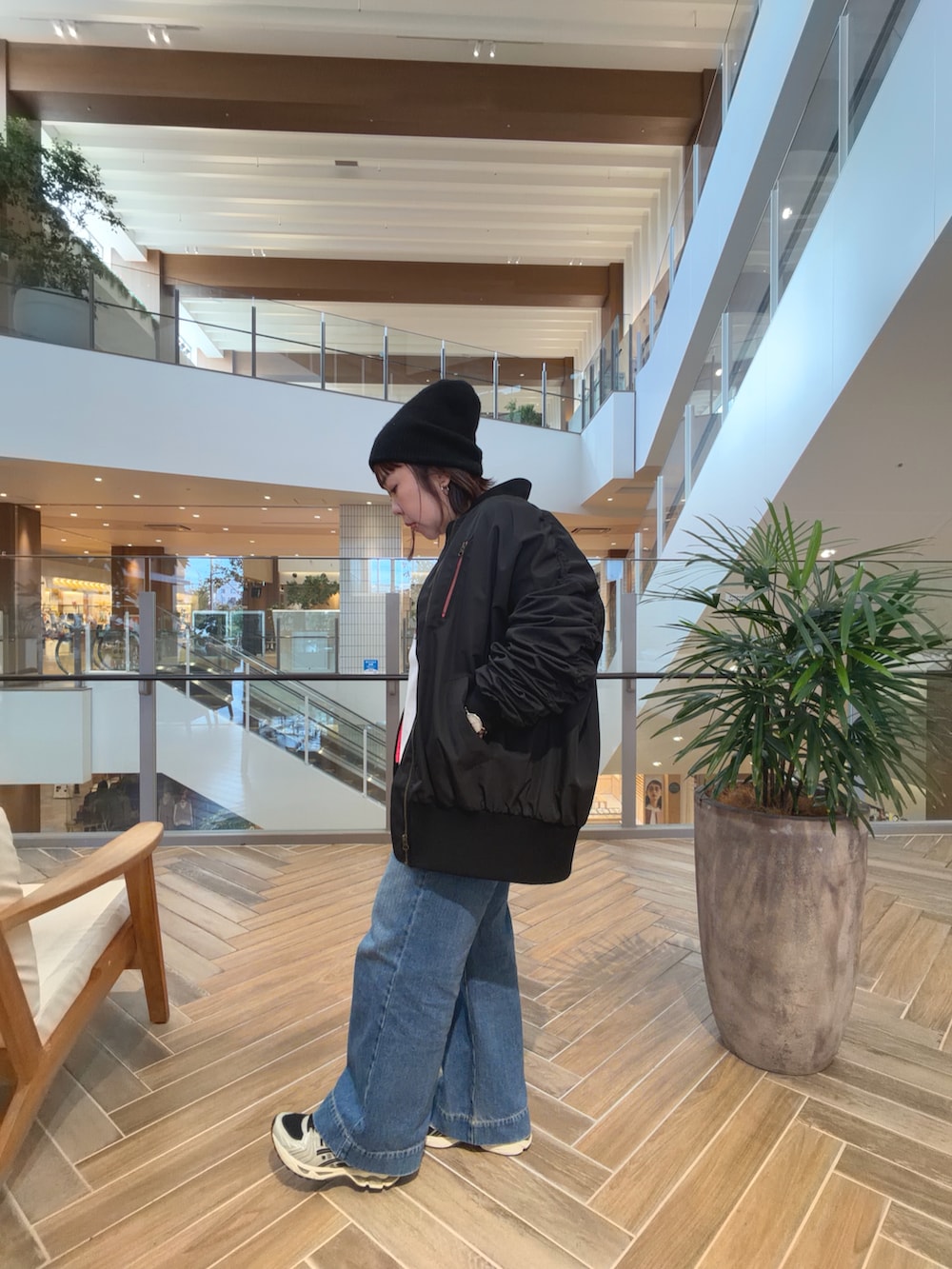 ブラック系のMA-1、ブルー系のデニムパンツを着用したレディースの秋コーディネートの2枚目の写真