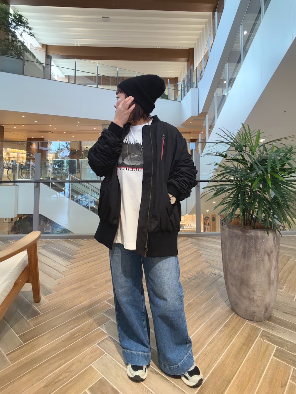 ブラック系のMA-1、ブルー系のデニムパンツを着用したレディースの秋コーディネートの3枚目の写真