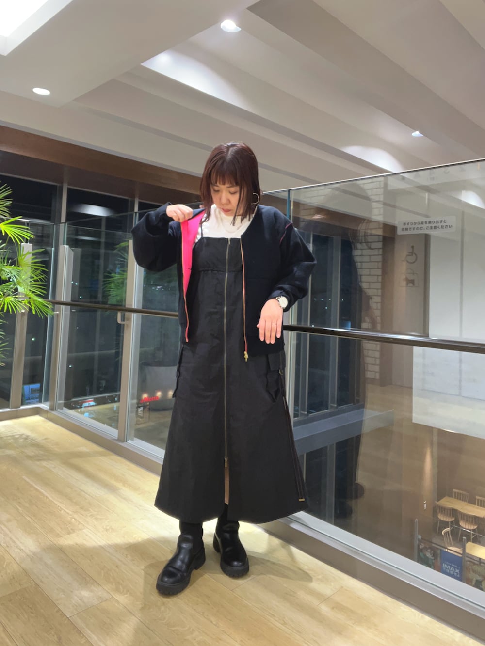 ブラック系のブルゾン、ブラック系のジャンパースカートを着用したレディースの秋コーディネートの2枚目の写真