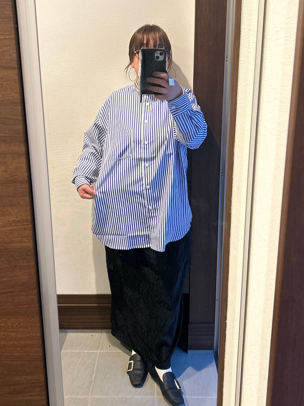 ブラック系のスカート、ブルー系のシャツ/ブラウス、グレー系のニット/セーターを着用したレディースの冬コーディネートの3枚目の写真