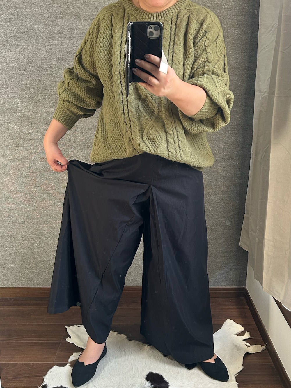 グリーン系のニット/セーター、ブラック系のパンツ、ブラック系のバッグを着用したレディースの冬コーディネートの4枚目の写真