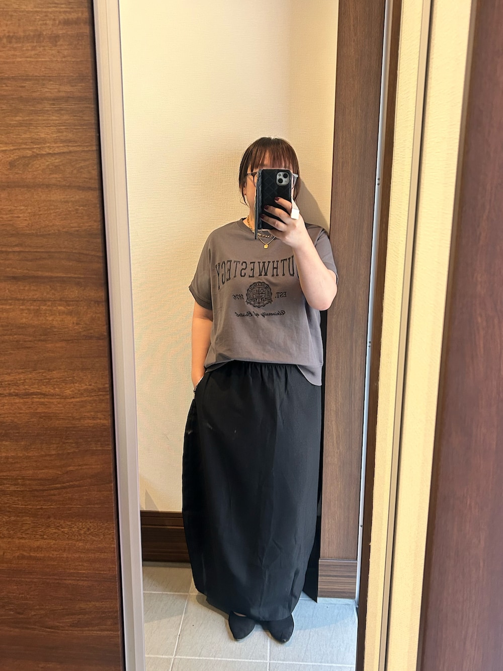 グレー系のTシャツ/カットソー、ブラック系のスカート、ブラック系のバッグを着用したレディースの夏コーディネートの4枚目の写真