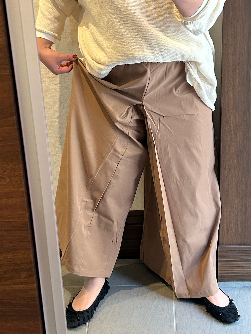 ホワイト系のニット/セーター、ホワイト系のTシャツ/カットソー、ブラック系のパンツを着用したレディースの冬コーディネートの3枚目の写真