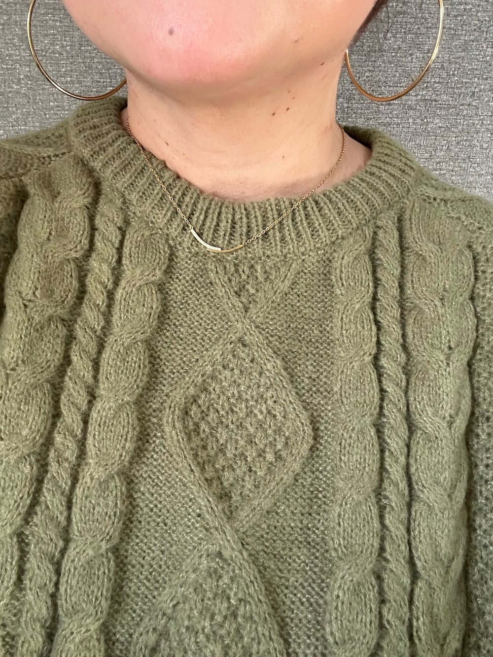 グリーン系のニット/セーター、ブラック系のパンツ、ブラック系のバッグを着用したレディースの冬コーディネートの5枚目の写真