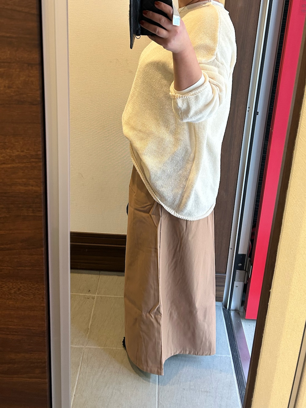 ホワイト系のニット/セーター、ホワイト系のTシャツ/カットソー、ブラック系のパンツを着用したレディースの冬コーディネートの2枚目の写真